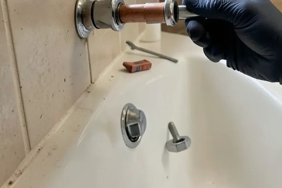 Slip-on tub spout removed to show the copper stub and set screw during a tub spout leak repair