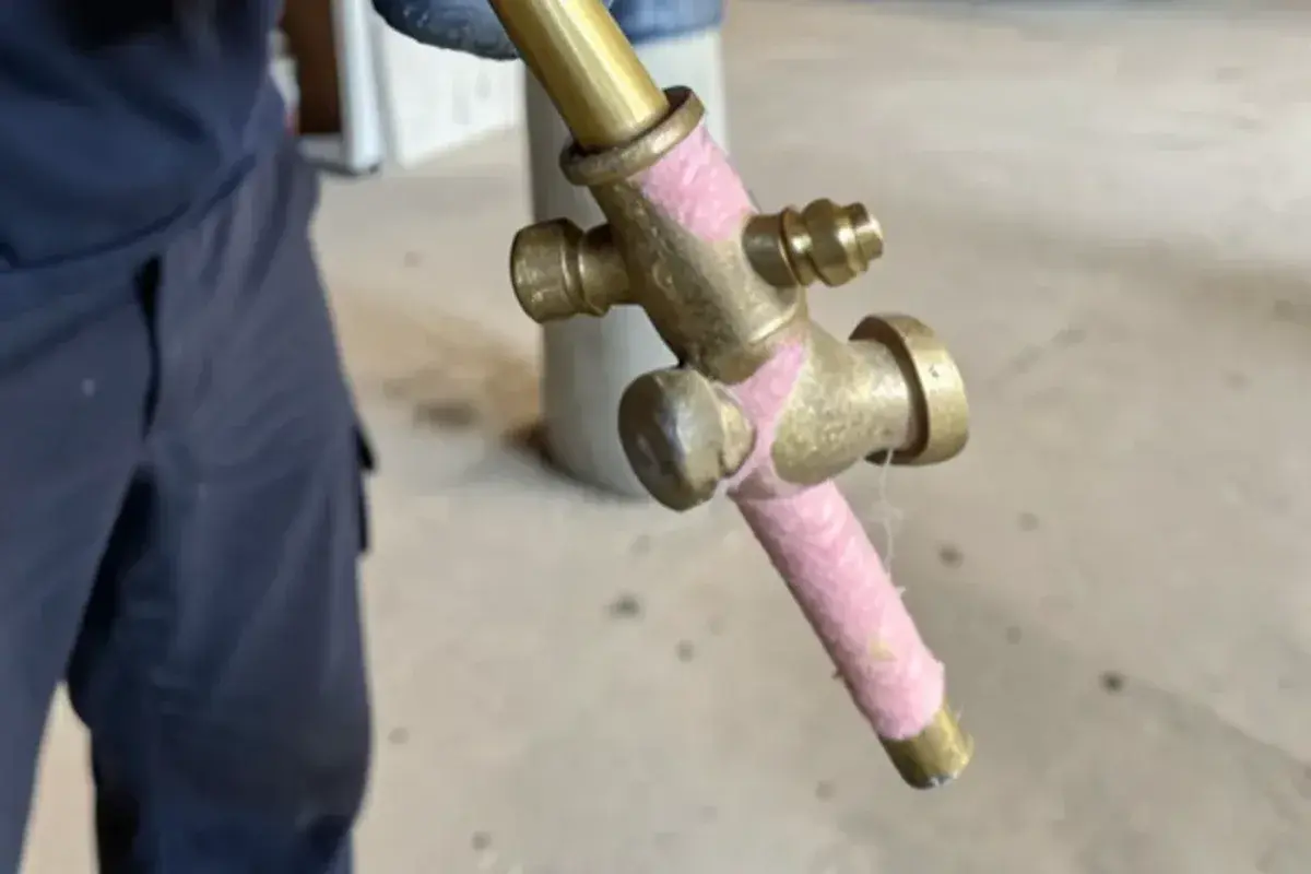 Frost-free sillcock pulled from a basement rim joist with a freeze split along its barrel